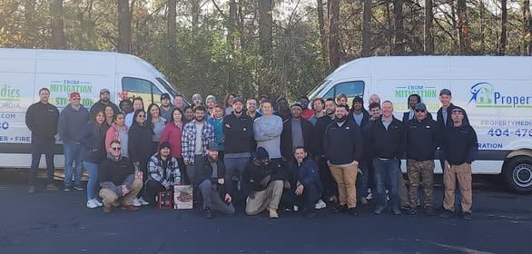 Property Medics of Georgia team members standing in front of their service vans