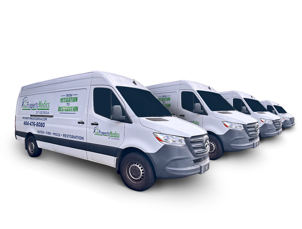 4 white vans with a Property Medics of Georgia logo