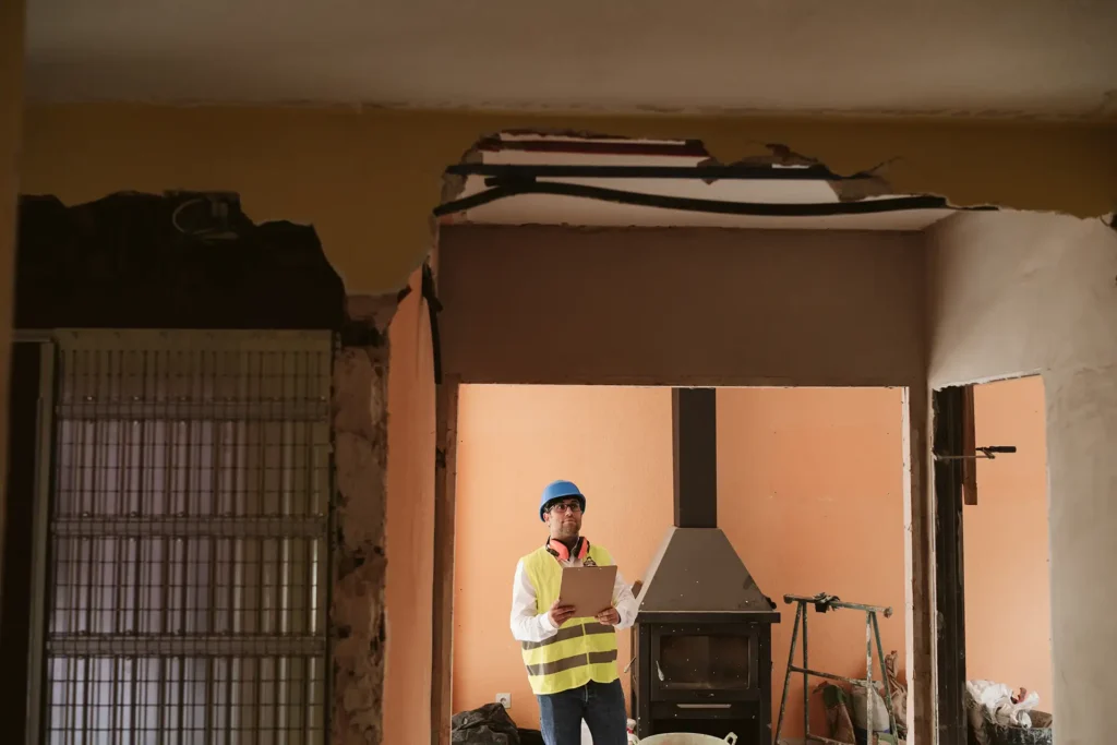 A worker inspecting roof damage in a home
